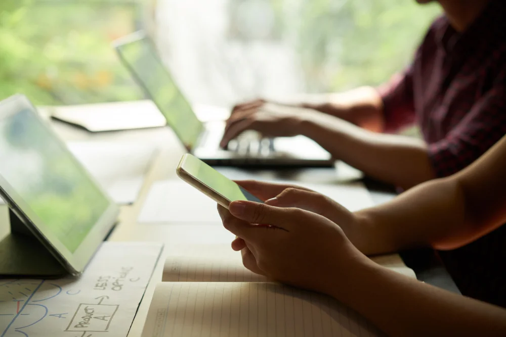 hands-business-person-checking-messages-smartphone-with-coworker